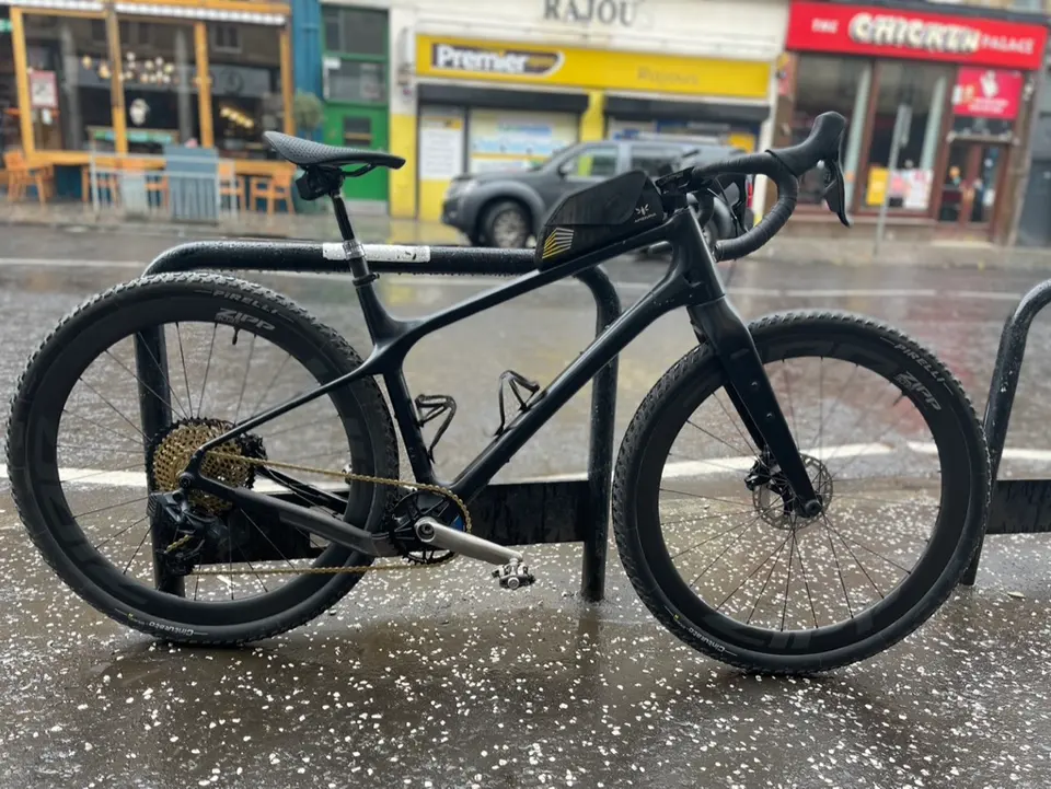 A black road bike with disc brakes parked on Gibson Street