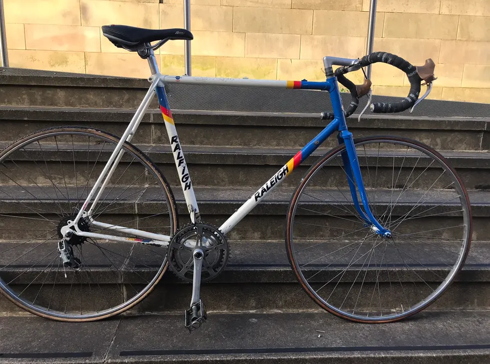 A blue and silver steel road bike on sandstone steps