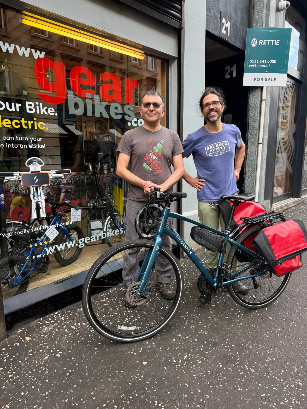 Two hire customers collecting their bikes outside the shop