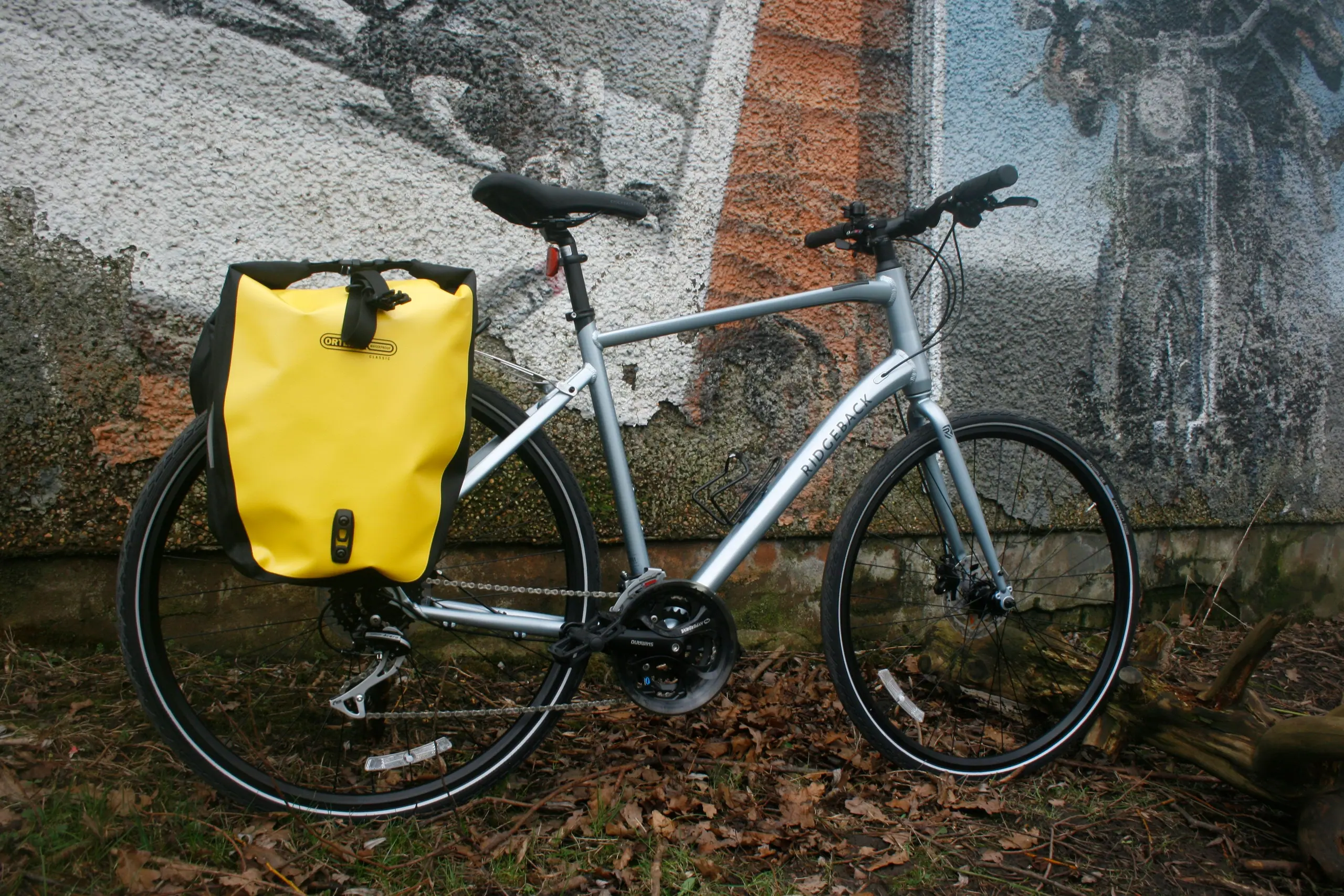 A silver Ridgeback Vanteo hire bike with a yellow Ortlieb pannier on the rear rack