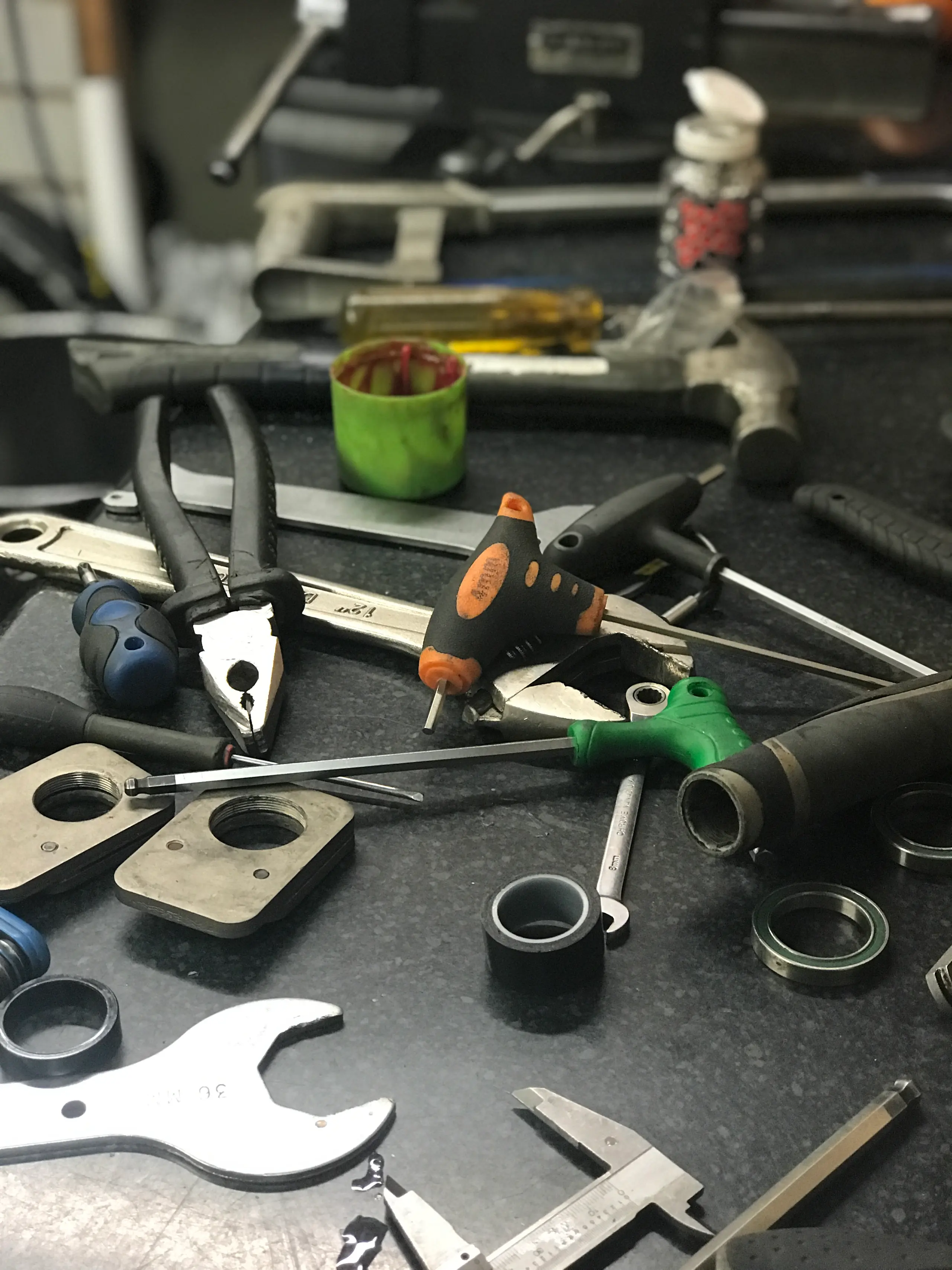 Cone spanners, a bottom bracket tool and a grease pot on the Gear Bikes workbench